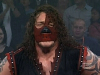 Abyss walks back and forth pacing as he stares at Janice propped up in ...
